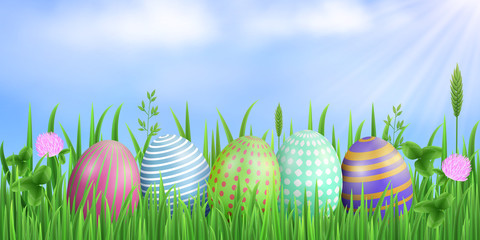 Spring easter rectangular background. Painted eggs, blue sky, sun rays, fresh green grass, flowers and clover leaves. Vector concept. EPS 10