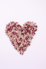 Dry purple beans for vegans in the form of a heart on a white background copy space. Healthy