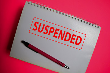 Suspended write on a book isolated on pink background.