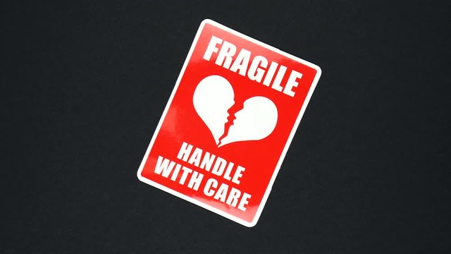 FRAGILE HANDLE WITH CARE warning sign word text