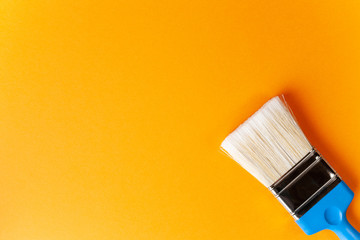 Paint brush on an orange background, horizontal orientation, copy paste.