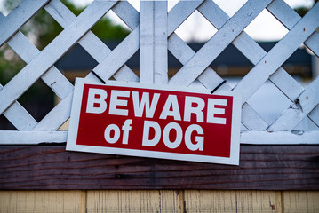 beware of guard dog sign on wooden gate