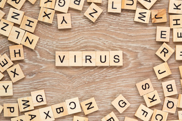 The word "Virus" spelt out with letter tiles on the wooden background