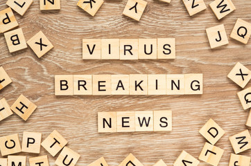 The words "Virus Breaking News" spelt out with letter tiles on the wooden background