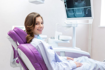 Happily smiling woman at dental clinic. 