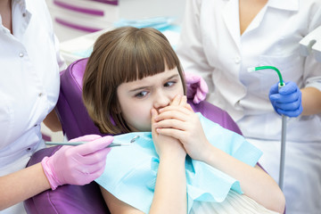 Scared small girl at dentist doctor appointment. 