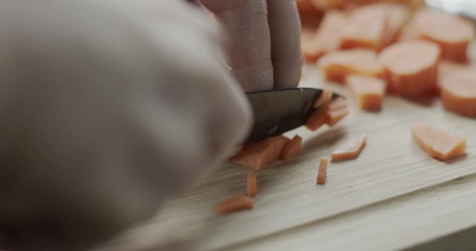 Cutting a carrot on a chopping board.