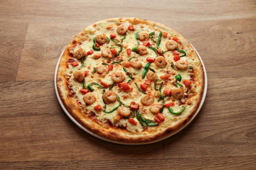 shrimp pizza with vegetables on a wooden background