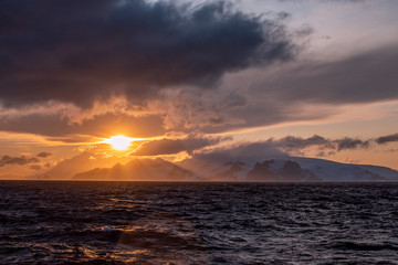 Sonnenuntergang in der Antarktis über dem Meer mit den Gletschern von Antarktika 