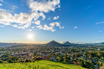 Sun in afternoon sky with Mountains, City, from View