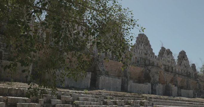 camara avanza hacia adelante, con flare del sol y luego un travelling apuntando a la muralla de uxmal