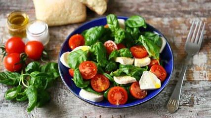 Selective focus. Healthy caprese salad in a blue plate. Italian style.