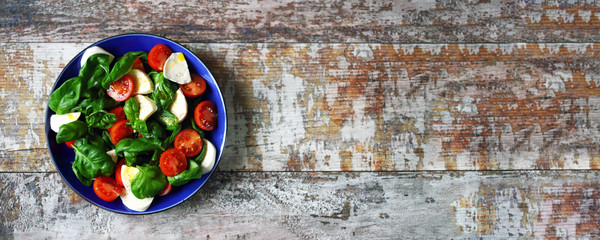 Selective focus. Healthy caprese salad in a blue plate. Italian style.