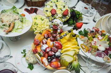 Rich banquet service. Wedding banquet. Catering food, snacks with cheese. Salad with shrimp. Different colorful meals for breakfast or lunch time. Restaurant interior