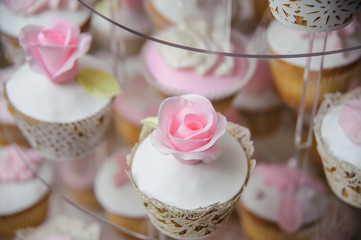 Luxurious pink wedding cake with flowers. Birthday, Valentine's day cake. Cupcakes  with pink roses. Wooden background