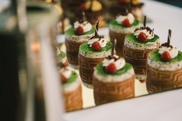 Süße Törtchen auf einer Kuchenplatte