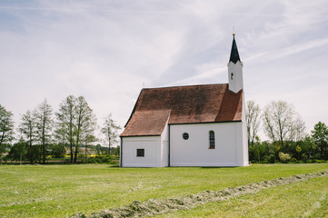 Fototapeta na wymiar Kleine weiße Kapelle auf grüner Wiese