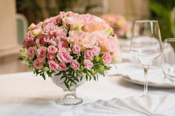 Colorful wedding bouquet on a restaurant served table. Bridal bouquet. Luxury royal restaurant. Valentine's day, birthday, dating or mother's day decoration
