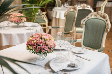 Colorful wedding bouquet on a restaurant served table. Bridal bouquet. Luxury royal restaurant. Valentine's day, birthday, dating or mother's day decoration
