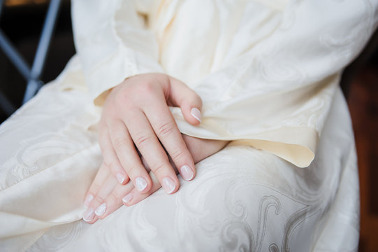Wedding preparations. Bride`s morning. Beautiful young woman in luxurious white wedding dress with lace. Bride's hands with accurate manicure