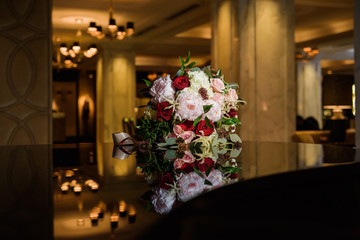 Colorful wedding bouquet on a black grand piano. Bridal colorful bouquet. Luxury hotel hall. Valentine's day or mother's day present