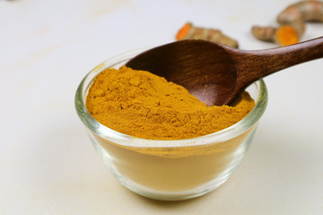 Turmeric powder in a separate glass cup on a white background is an ingredient in turmeric foods and ingredients in skin care products. Turmeric helps the skin to be strong.