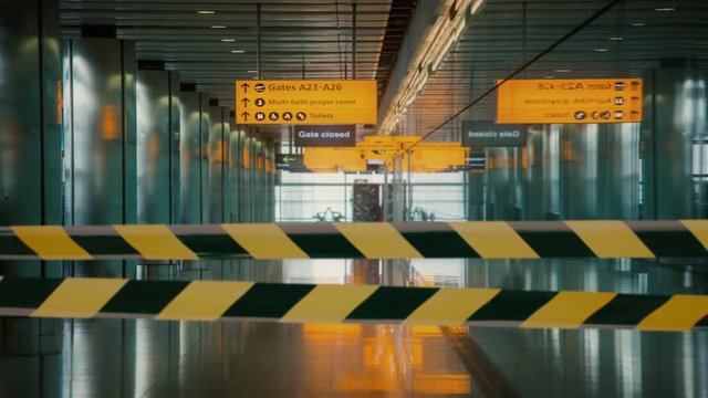 An empty international airport terminal during coronavirus infection.
Striped protective tape in slow motion.