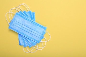 Medical masks for protection against flu and coronavirus on yellow background.