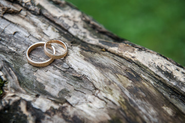 Golden wedding rings on a vintage wooden texture background. Close-up, macro