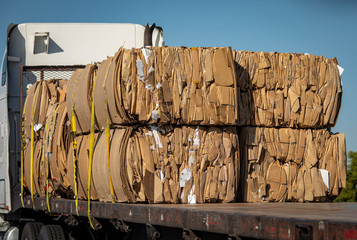 Cardboard boxes broken down and pressed into bales and loaded onto a flatbed truck