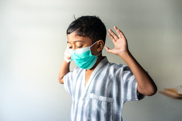 Young Muslim Boy wearing a mask praying. Covid-19 coronavirus concept. Shallow depth of field.