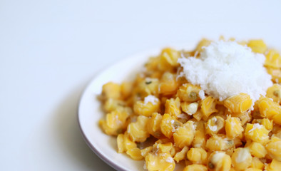 Grontol jagung on white background.  Grontol jagung is traditional snacks in Indonesia. Boiled shelled corn sprinkled with grated coconut.