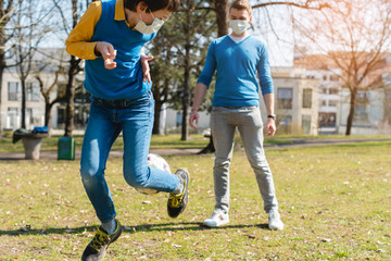 Dad and son playing soccer in park during coronavirus crisis
