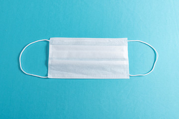 Surgical mask over minimalist blue background