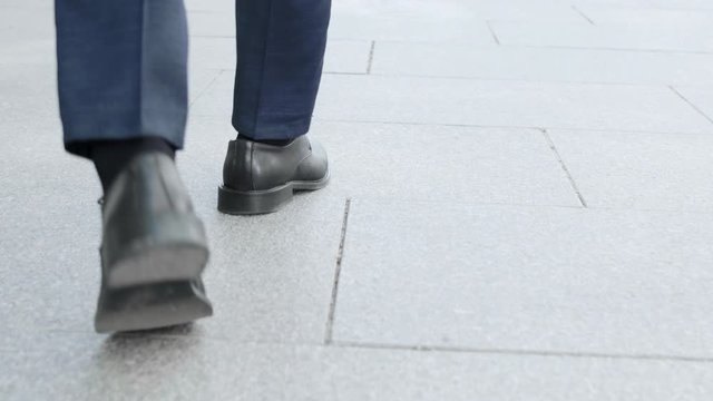 Businessman taking walk on street. Male executive wearing black shoes outside