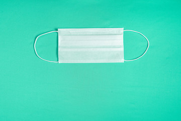 Surgical mask over minimalist green background