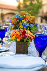 Table set for an event or wedding with blue glassware and flowers