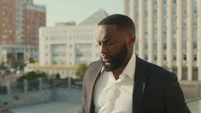 Businessman walking on street. Business man in suit looking at camera outdoors