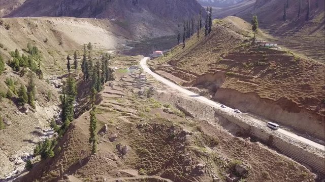 A group tour bus going in mountains of northern pakistan in naran valley going hunza via lulusar and babusar top - Aerial shot backview of bus