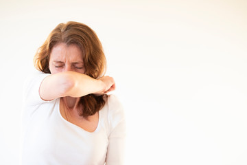woman coughing or sneezing in her elbow