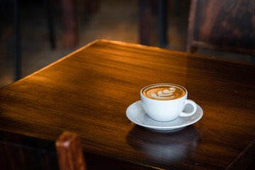 Digital tablet and cup of coffee on old wooden desk. / selective focus