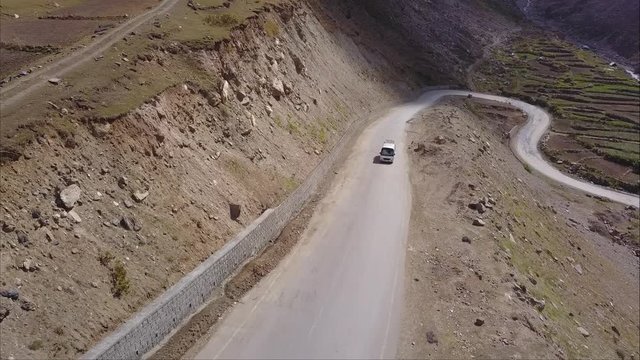 A group tour bus going in mountains of northern pakistan in naran valley going hunza via lulusar and babusar top - Aerial shot front view of bus