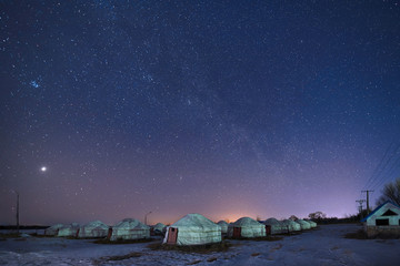 Mongolian yurts on the grassland in winter starry sky.