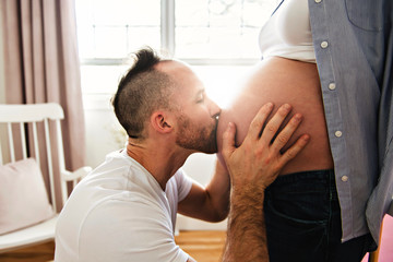 husband on the baby room at home with pregnant woman belly - obrazy, fototapety, plakaty