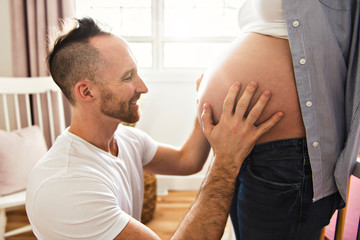 husband on the baby room at home with pregnant woman belly