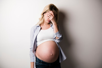 Pregnant woman with a lot of stress on white background