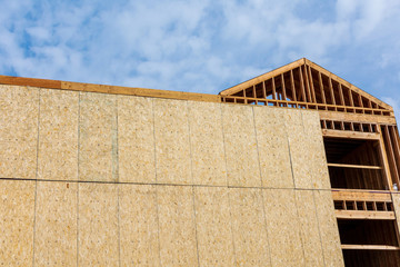 Exterior view of wood framed building construction with almost finished exterior walls under cloudy sky