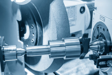 The metal shaft parts on cylindrical grinding machine for surface finishing process. The automotive...