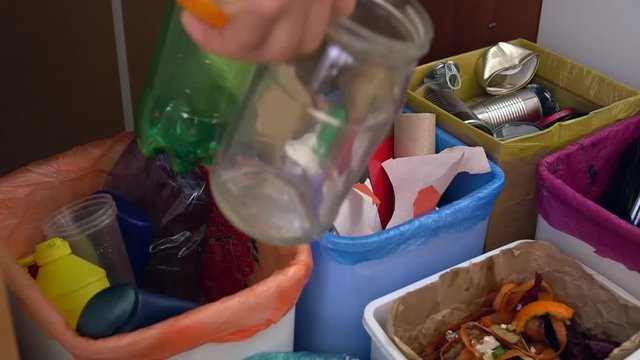 Housewife sorts household waste. Recycling Indoors Bin Colorful Bags. Wastebaskets for waste sorting in the kitchen 