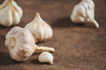 Garlic cloves and garlic on an old wooden table